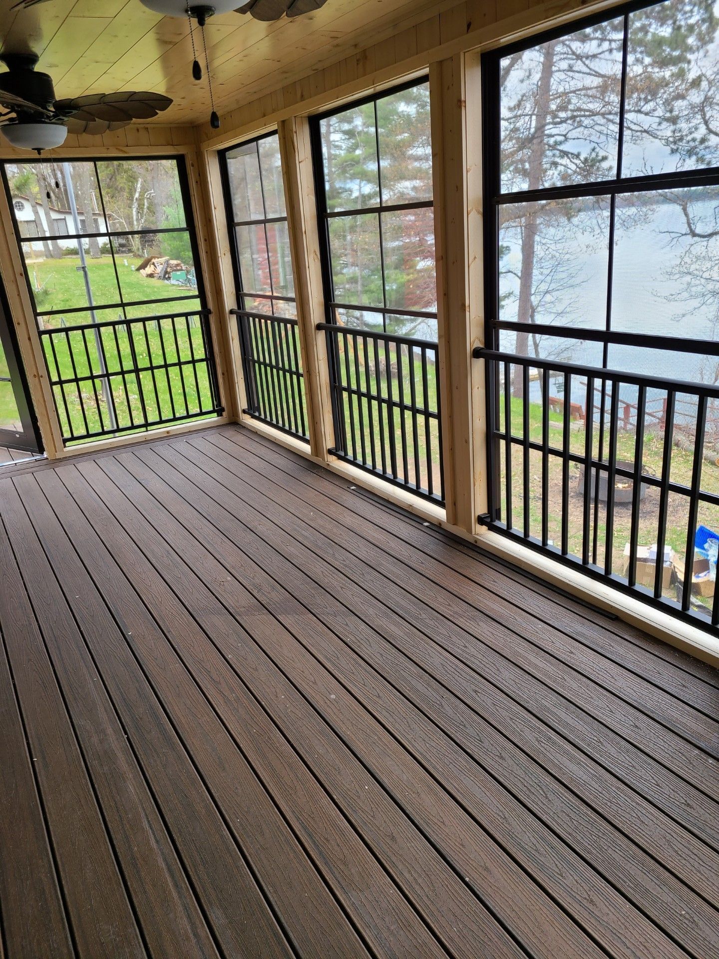 A screened in porch with a view of a lake.