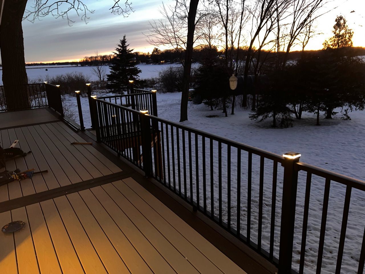 A deck with a railing overlooking a snowy field