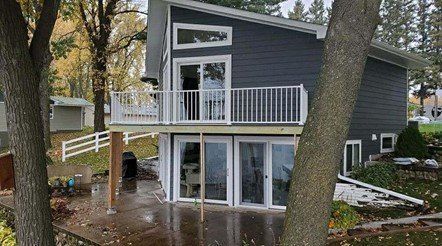 A small house with a deck on the side of it.