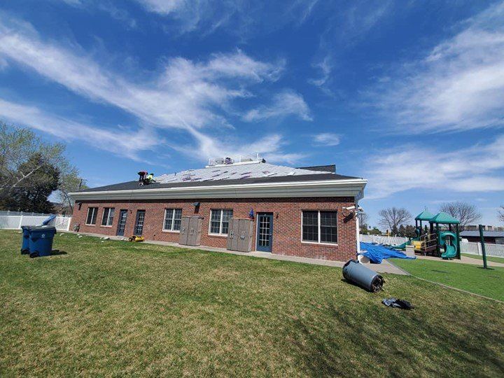 A large brick building with a roof that is being installed.