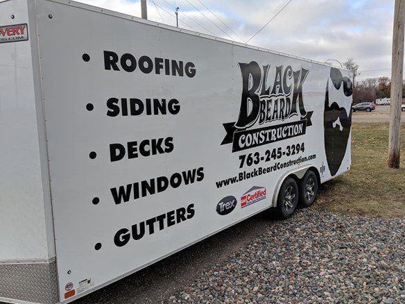 A white trailer with black beard construction written on it