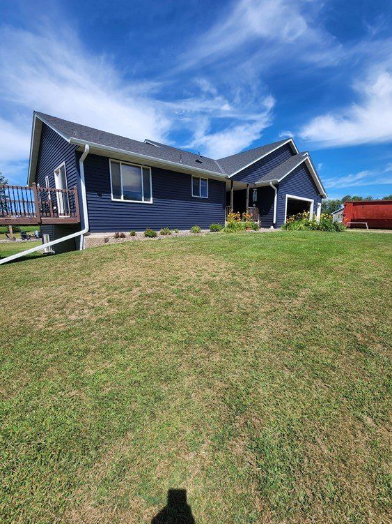 A blue house is sitting on top of a lush green lawn.