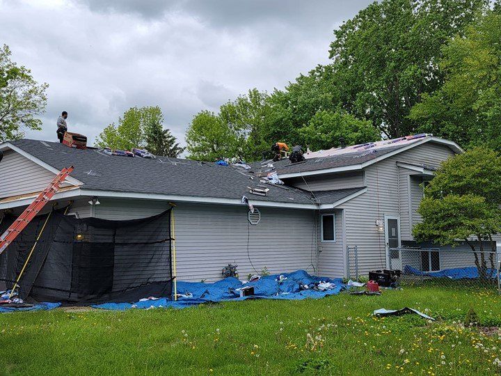 A group of people are working on the roof of a house.