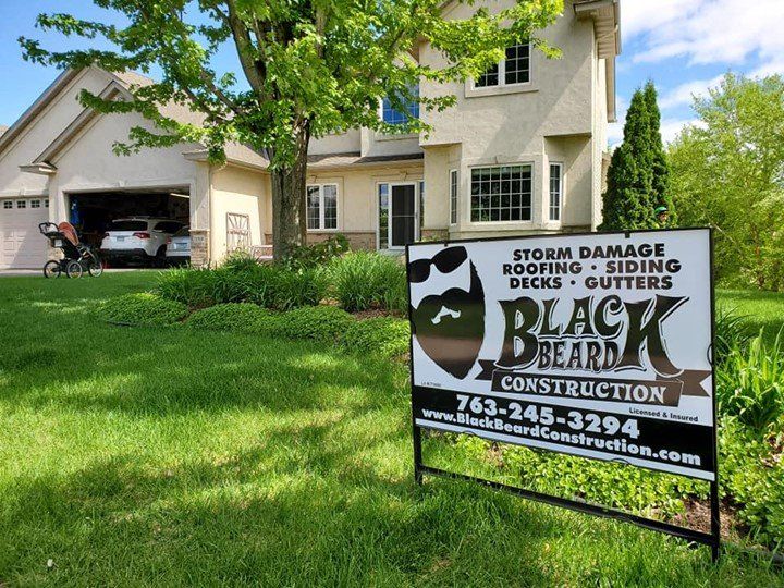 A black beard construction sign in front of a house