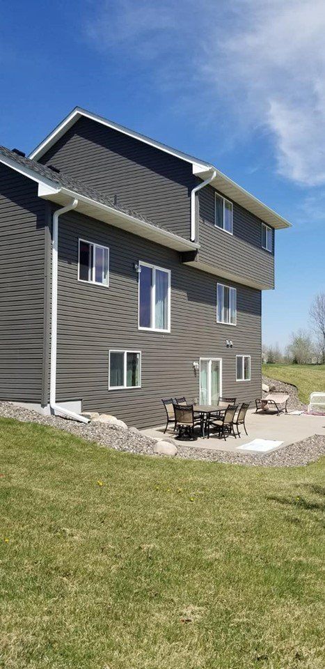 A large house with a patio and a table and chairs in front of it.