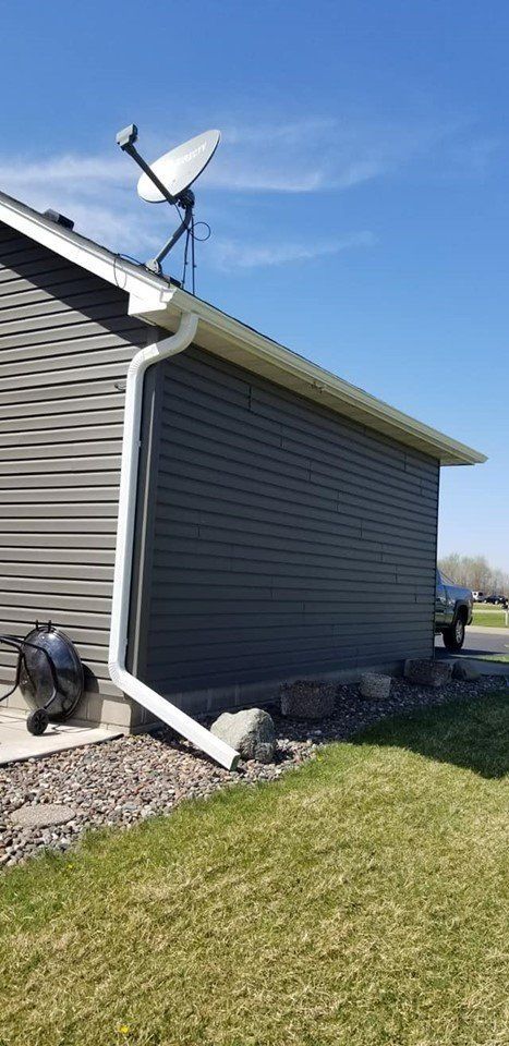 A house with a satellite dish on the roof and a gutter.