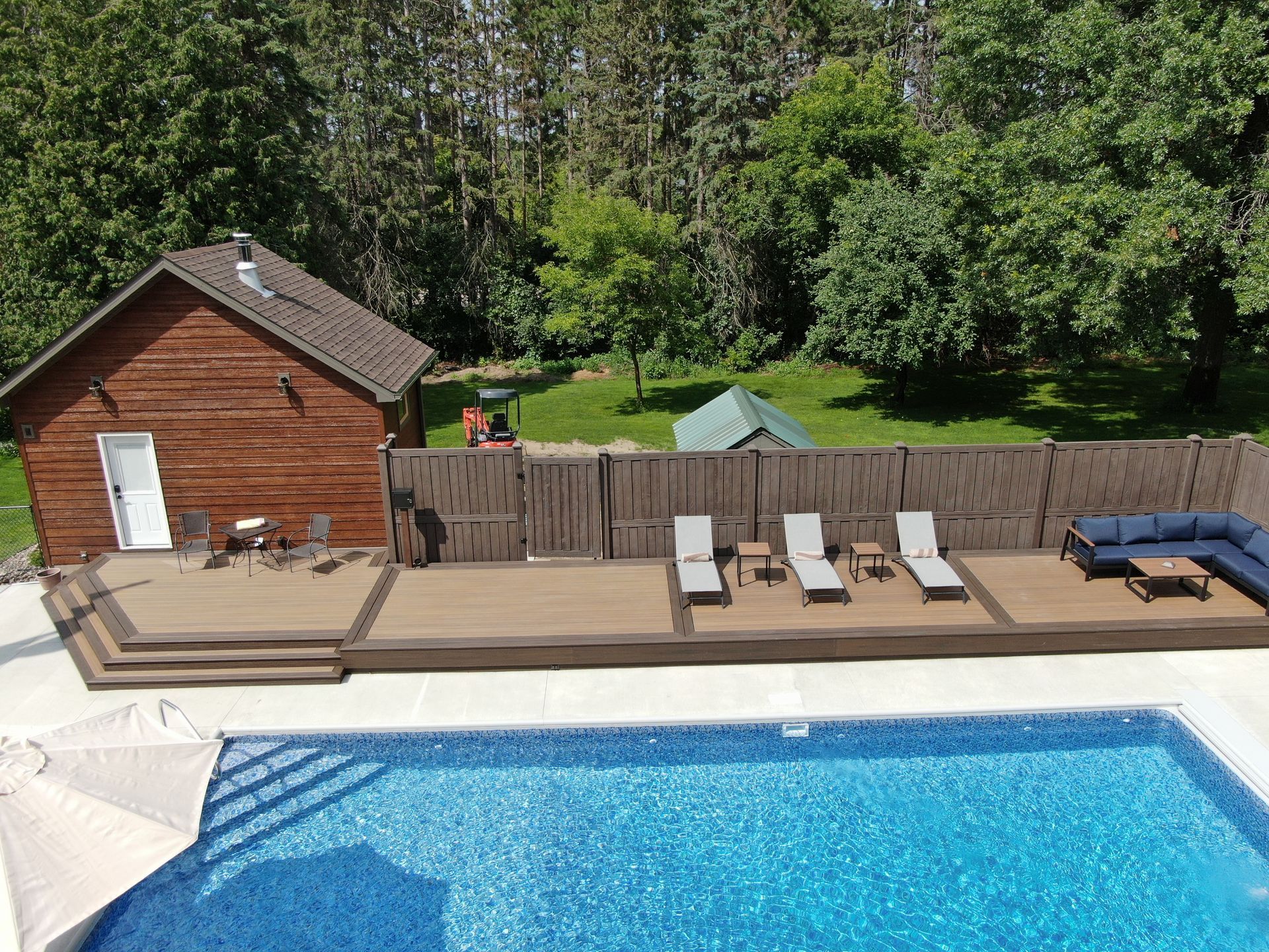 An aerial view of a house with a swimming pool and a deck.