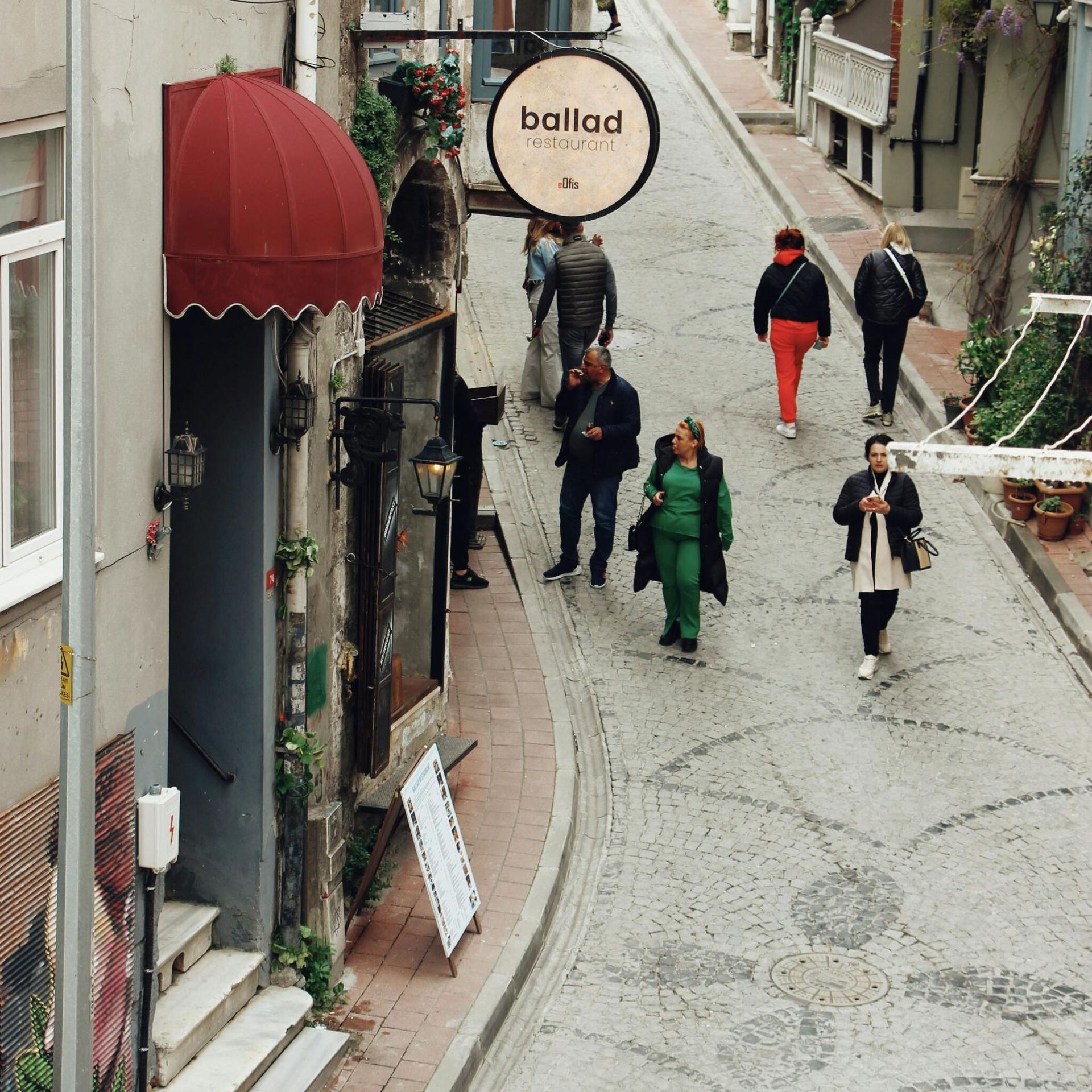 A group of people walking down a street with a ballad sign above them for Fraser Corporate Finance.