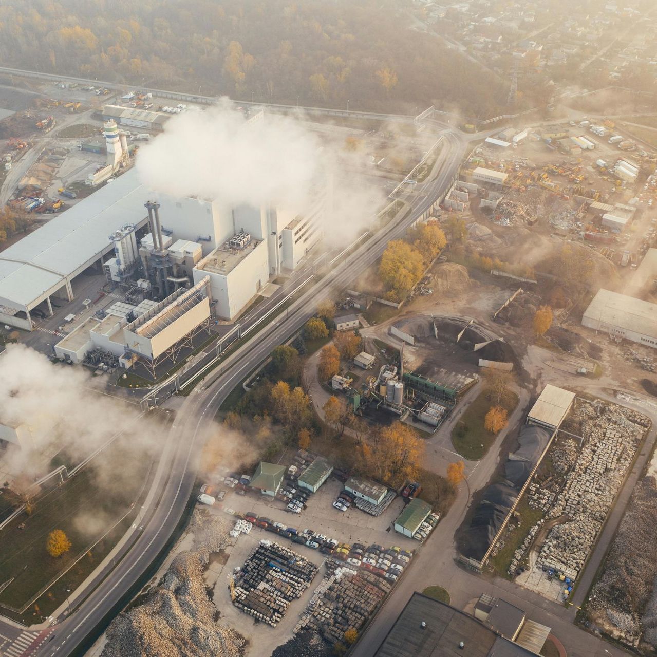 An aerial view of a factory with smoke coming out of it for Fraser Corporate Finance.