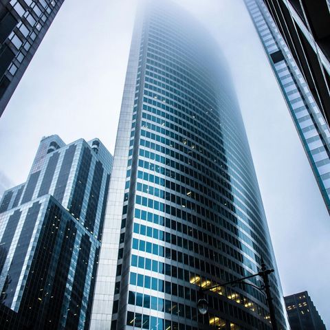 Looking up at a tall building in the fog for Fraser Corporate Finance.