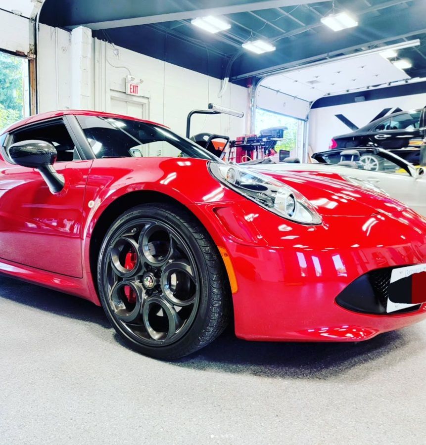 A red Alfa Romeo in our auto shop for routine inspection and maintenance
