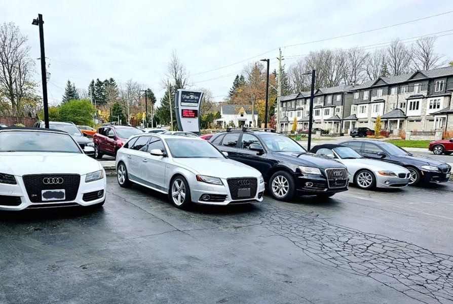 A row of Audis parked in the parking lot of Village Auto Service