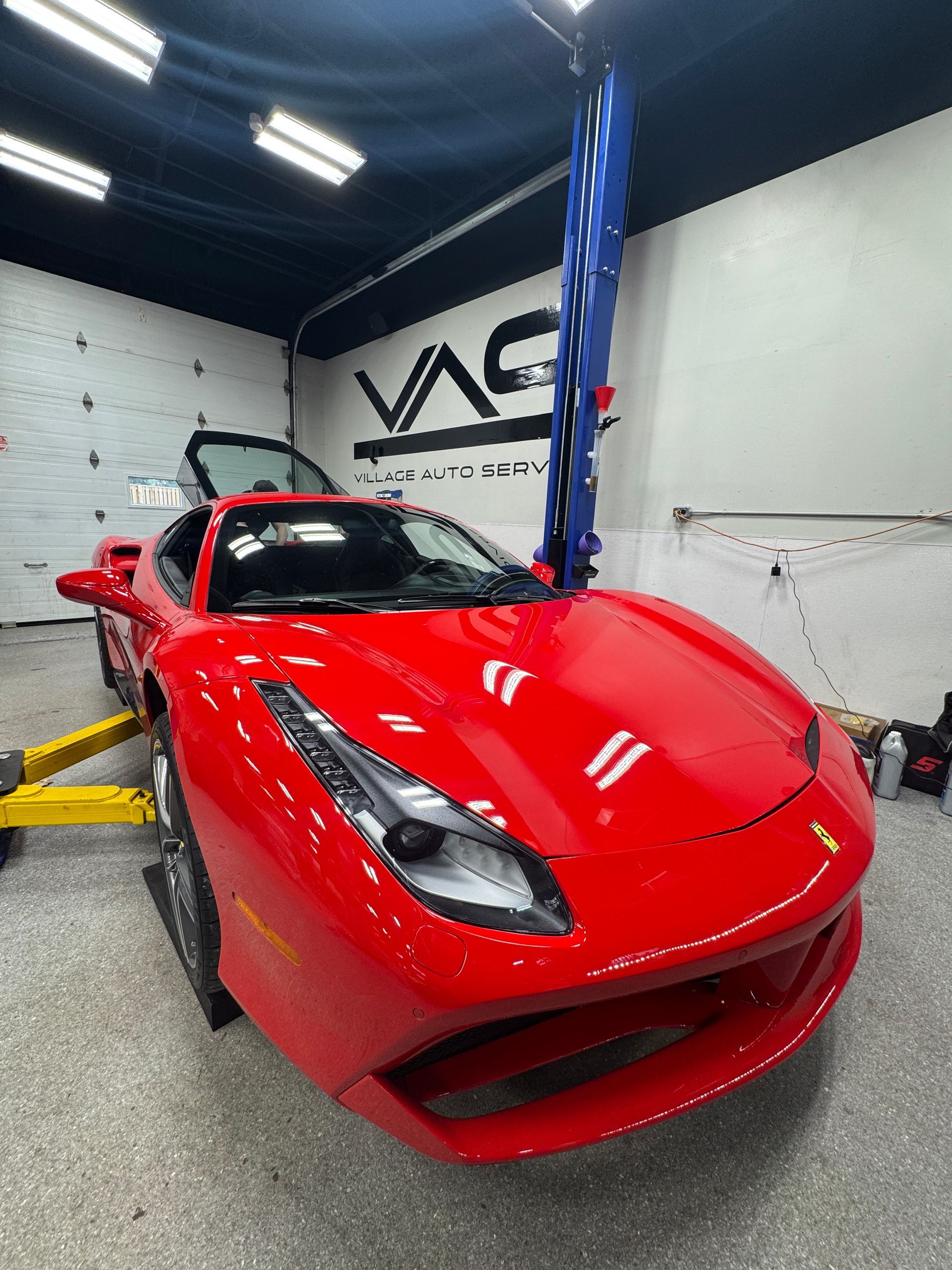 A red Ferrari parked in our auto repair shop for service