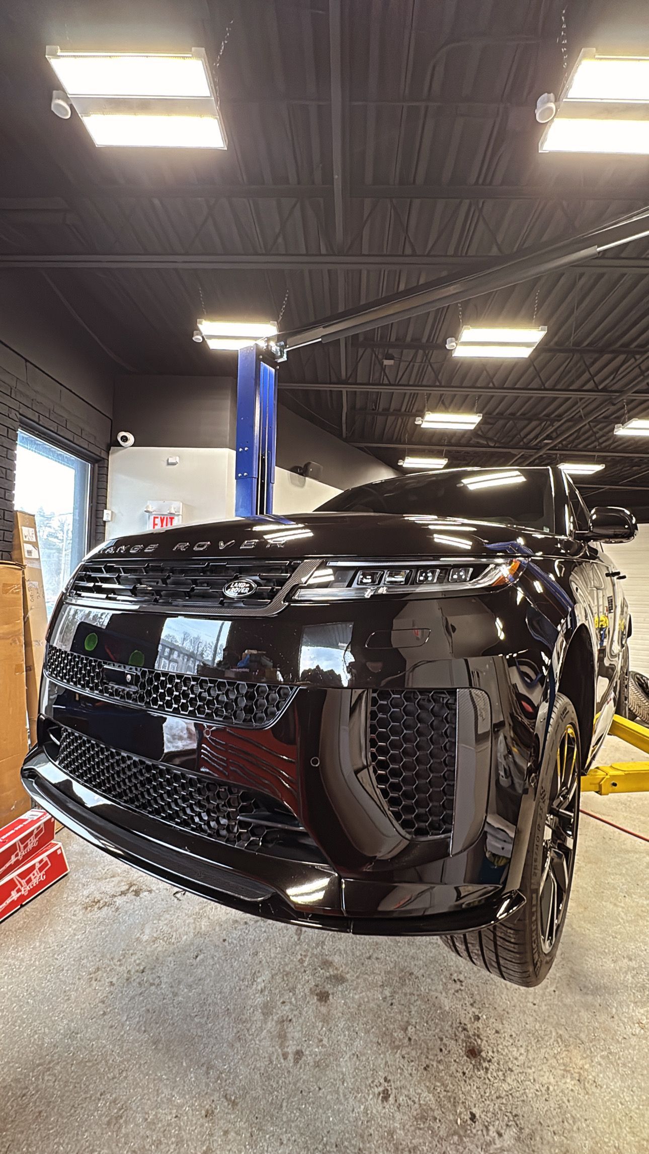A black Land Rover suspended in our shop for diagnosis and mechanical repairs
