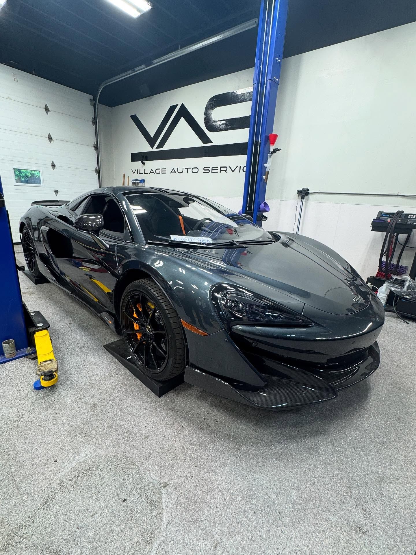 Get the expert service that supercar lovers have trusted in Hamilton for decades. Black McLaren parked inside Village Auto Service for car maintenance.