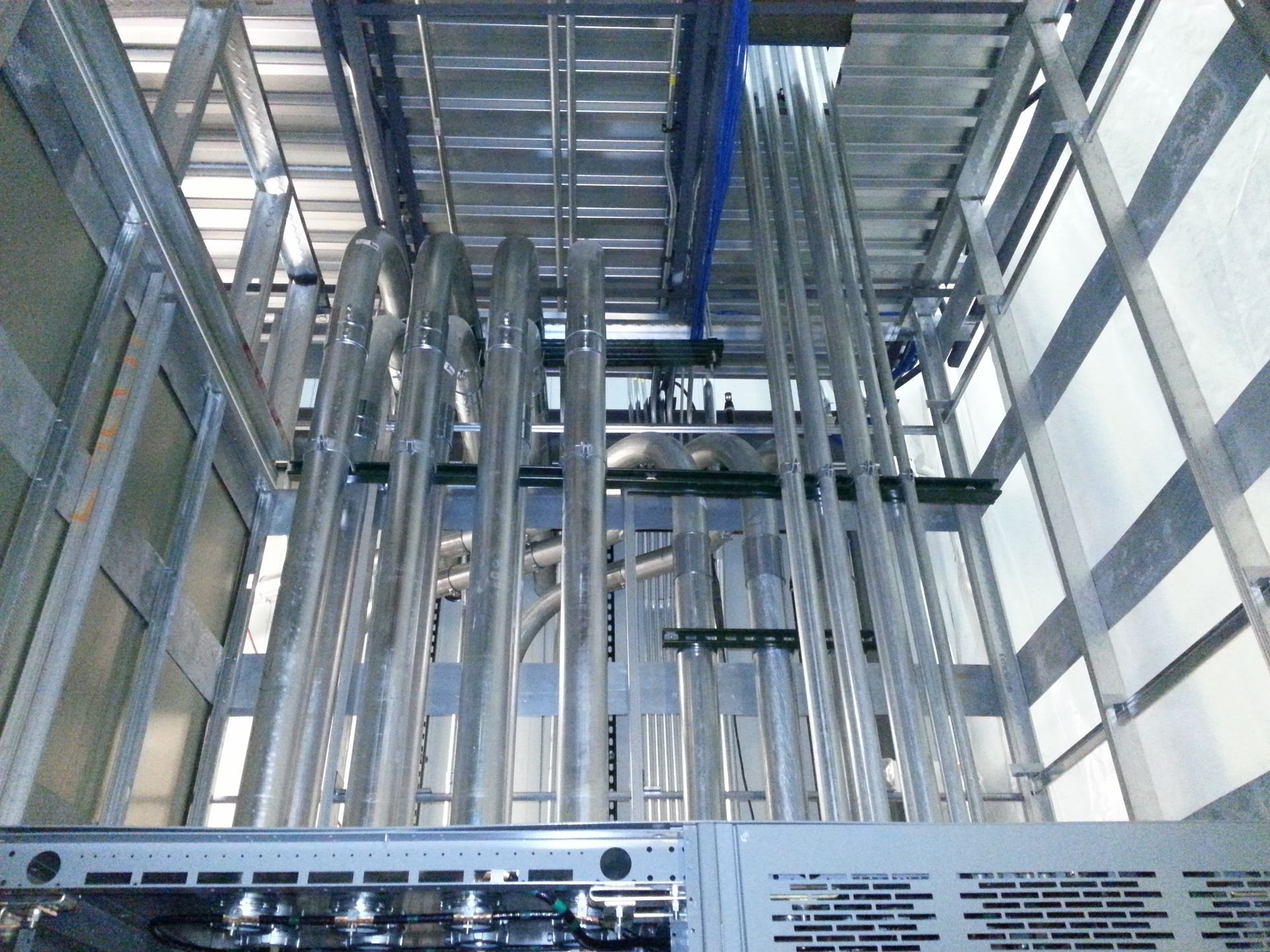 A bunch of metal pipes are hanging from the ceiling