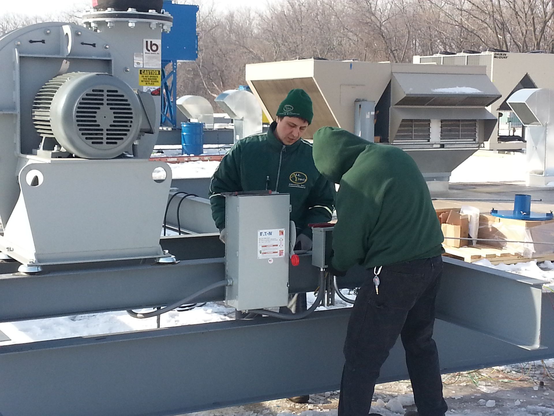 A man in a green jacket is working on a machine