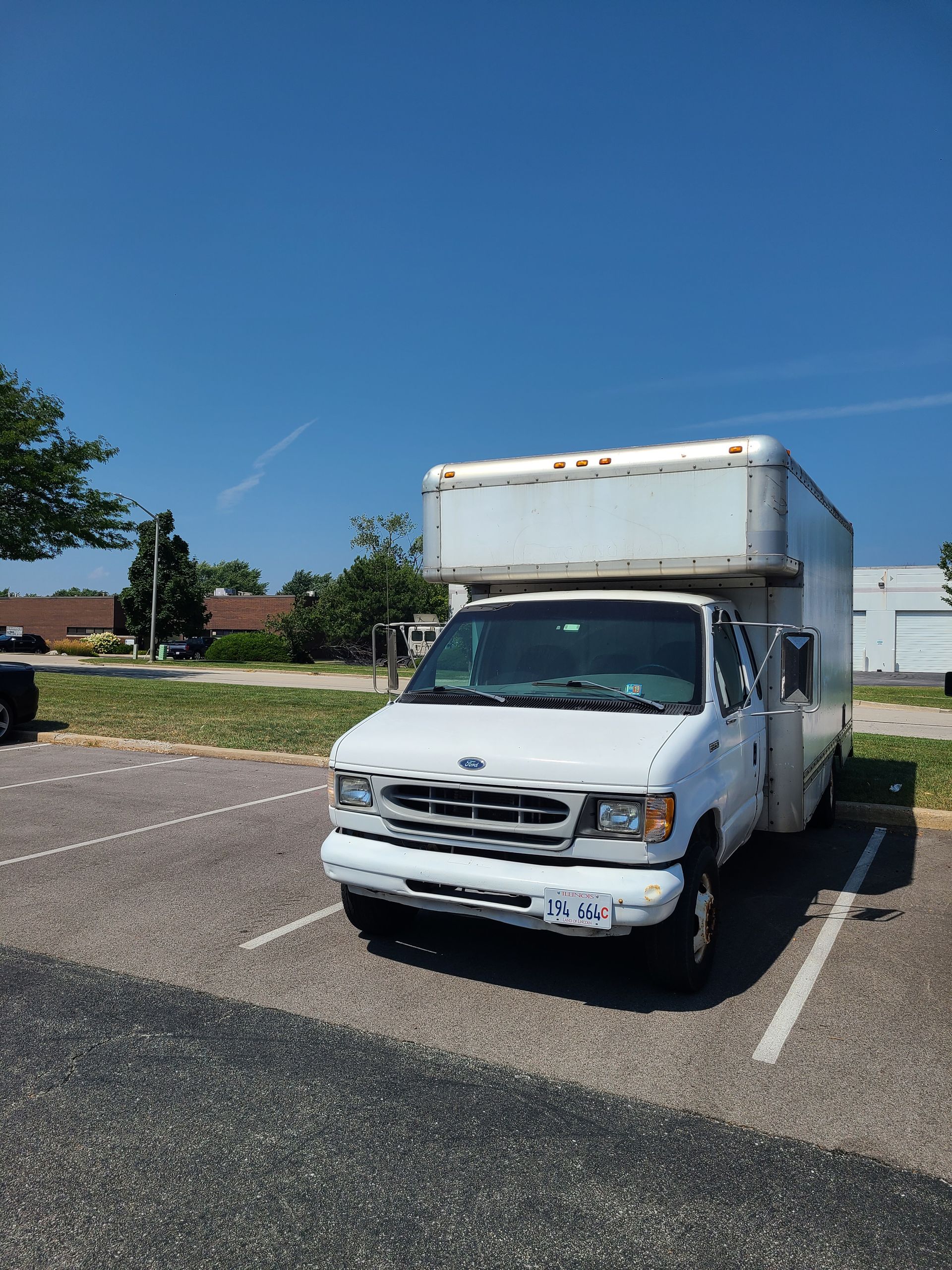 A white truck is parked in a parking lot.