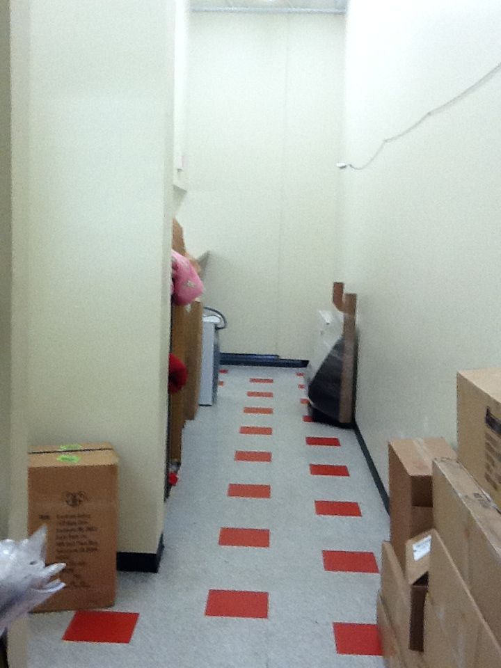 A hallway with boxes on the floor and one that says ' fragile ' on it