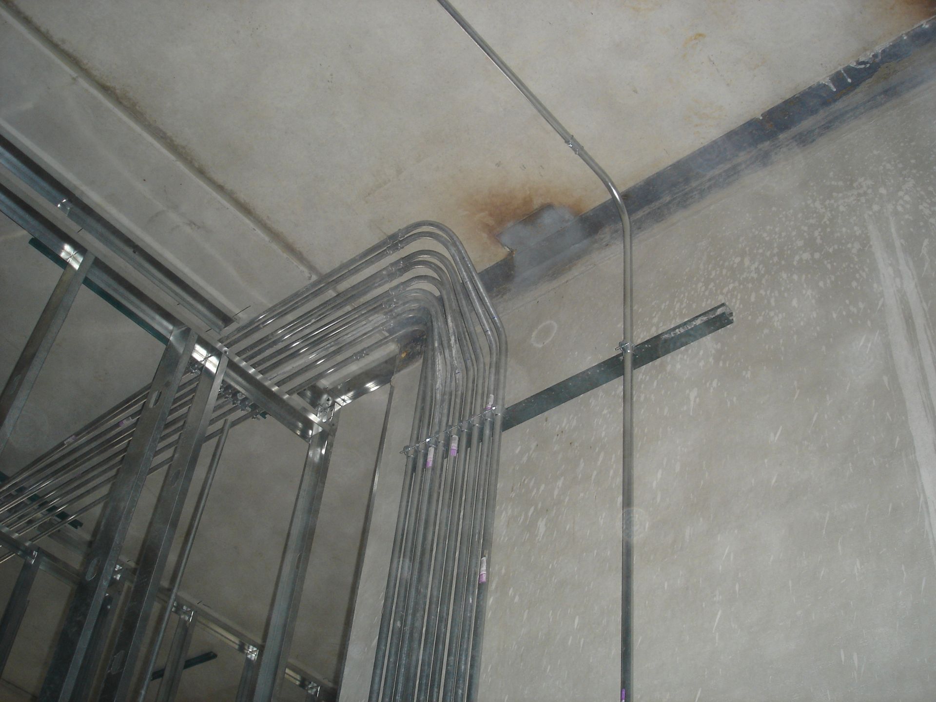 A bunch of metal pipes are hanging from the ceiling