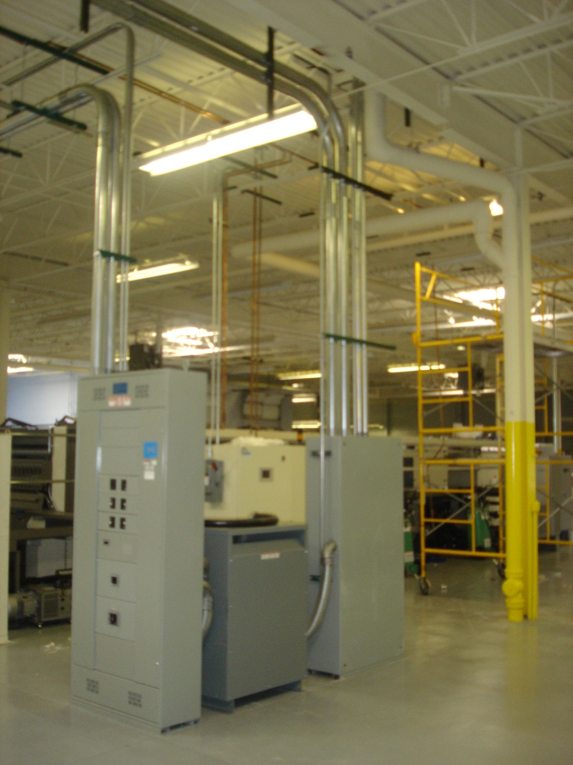 A warehouse with a lot of pipes and electrical boxes