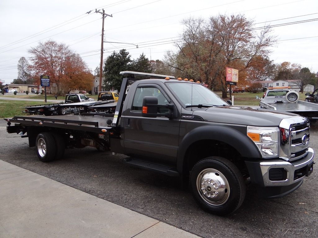 A gray tow truck is parked on the side of the road.