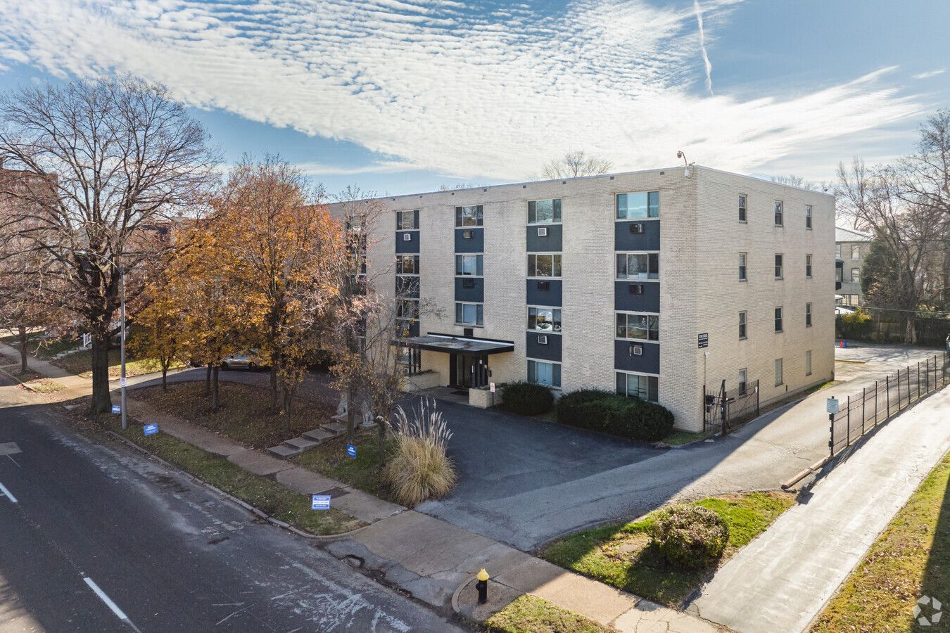 An aerial view of a large apartment building next to a street.