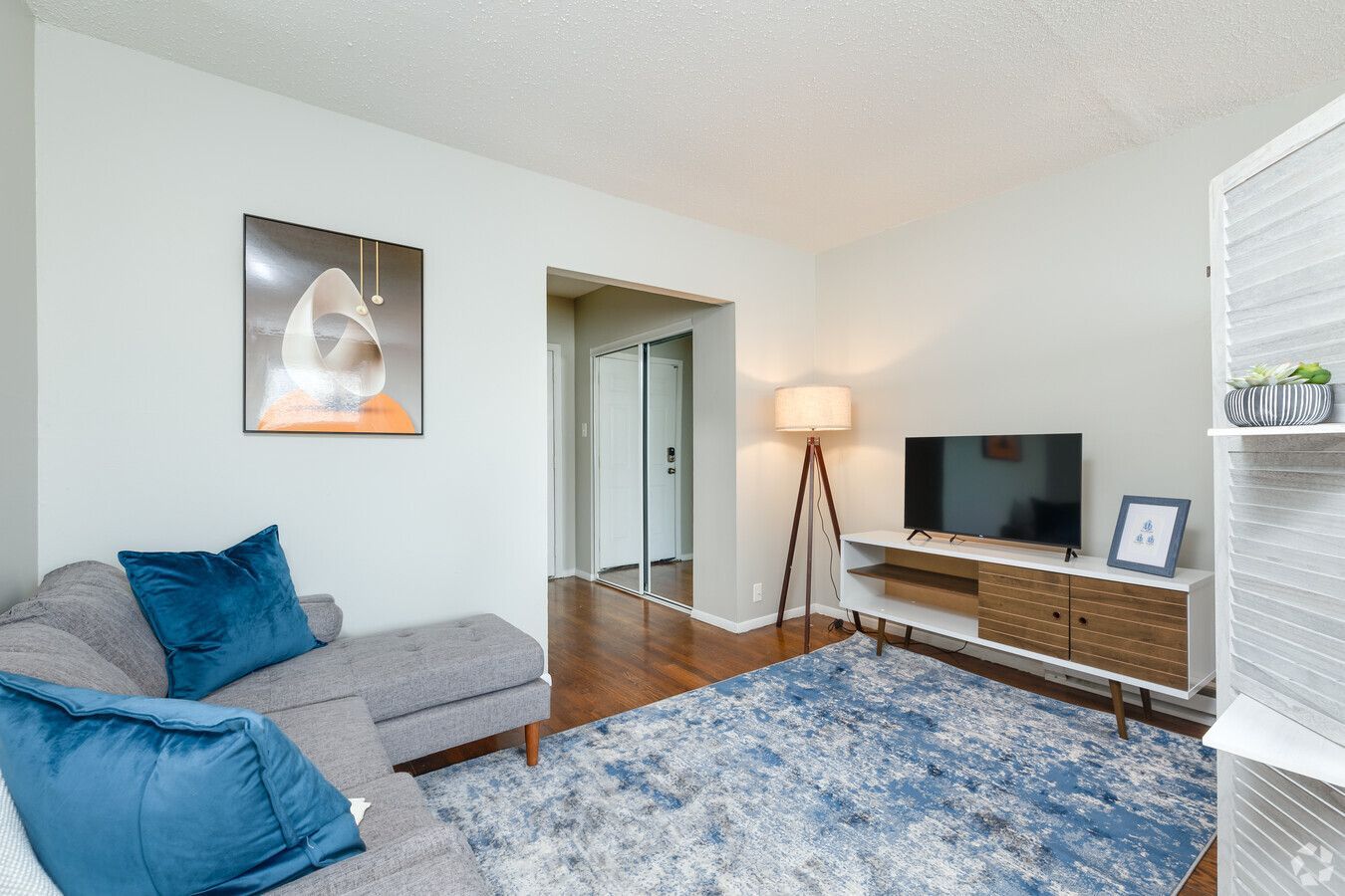A living room with a couch , television , and rug.