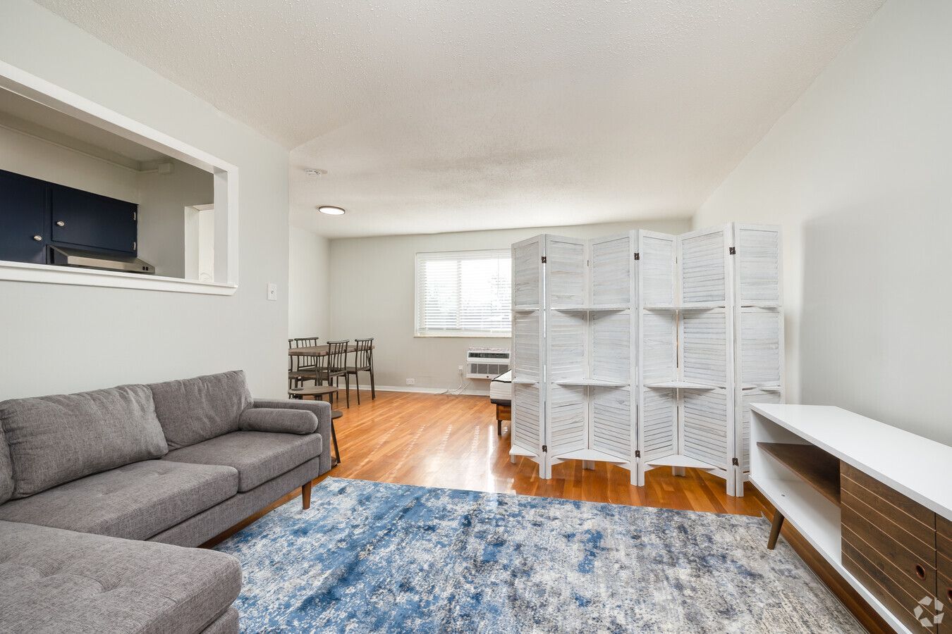 A living room with a couch , chair , and rug.