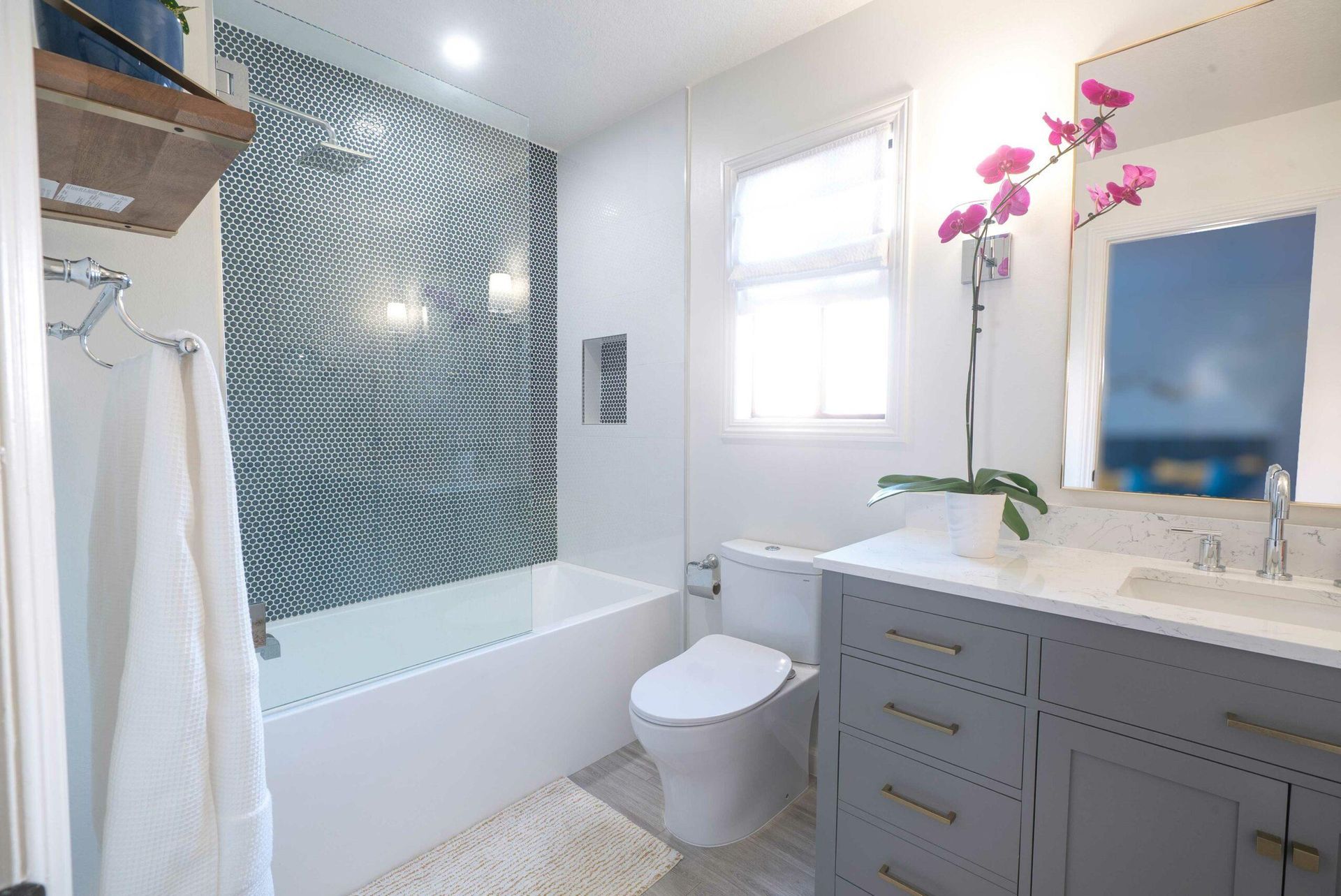 A bathroom with a toilet , sink , bathtub and shower.