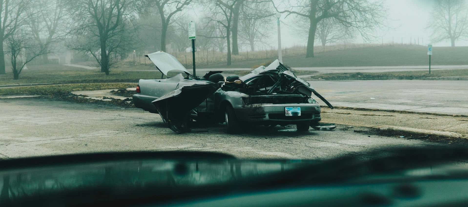 A man is standing next to a car that has crashed into another car.