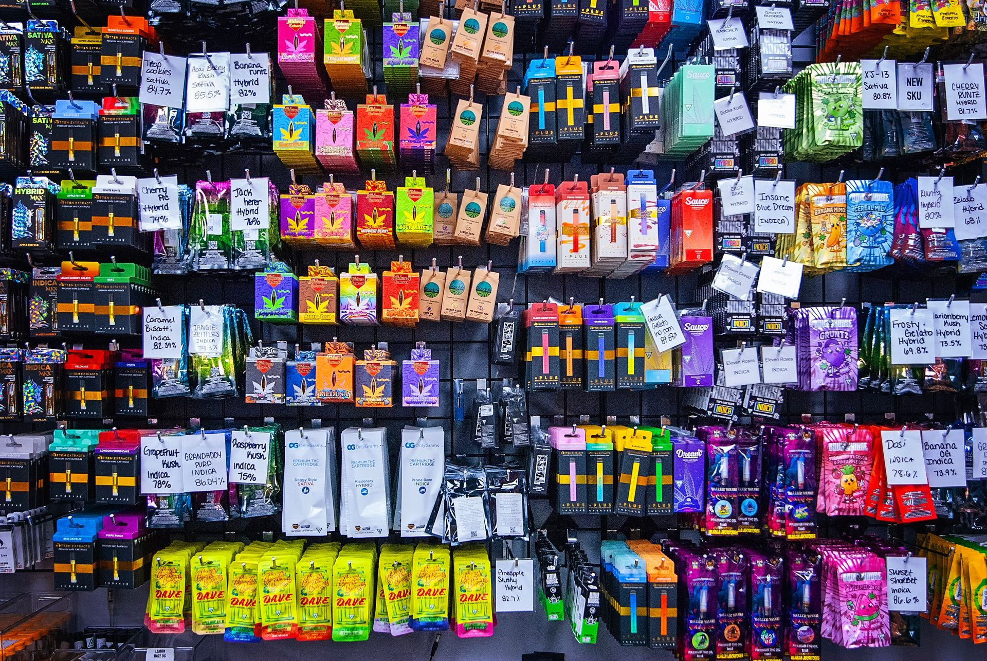 There are many different types of batteries hanging on the wall.