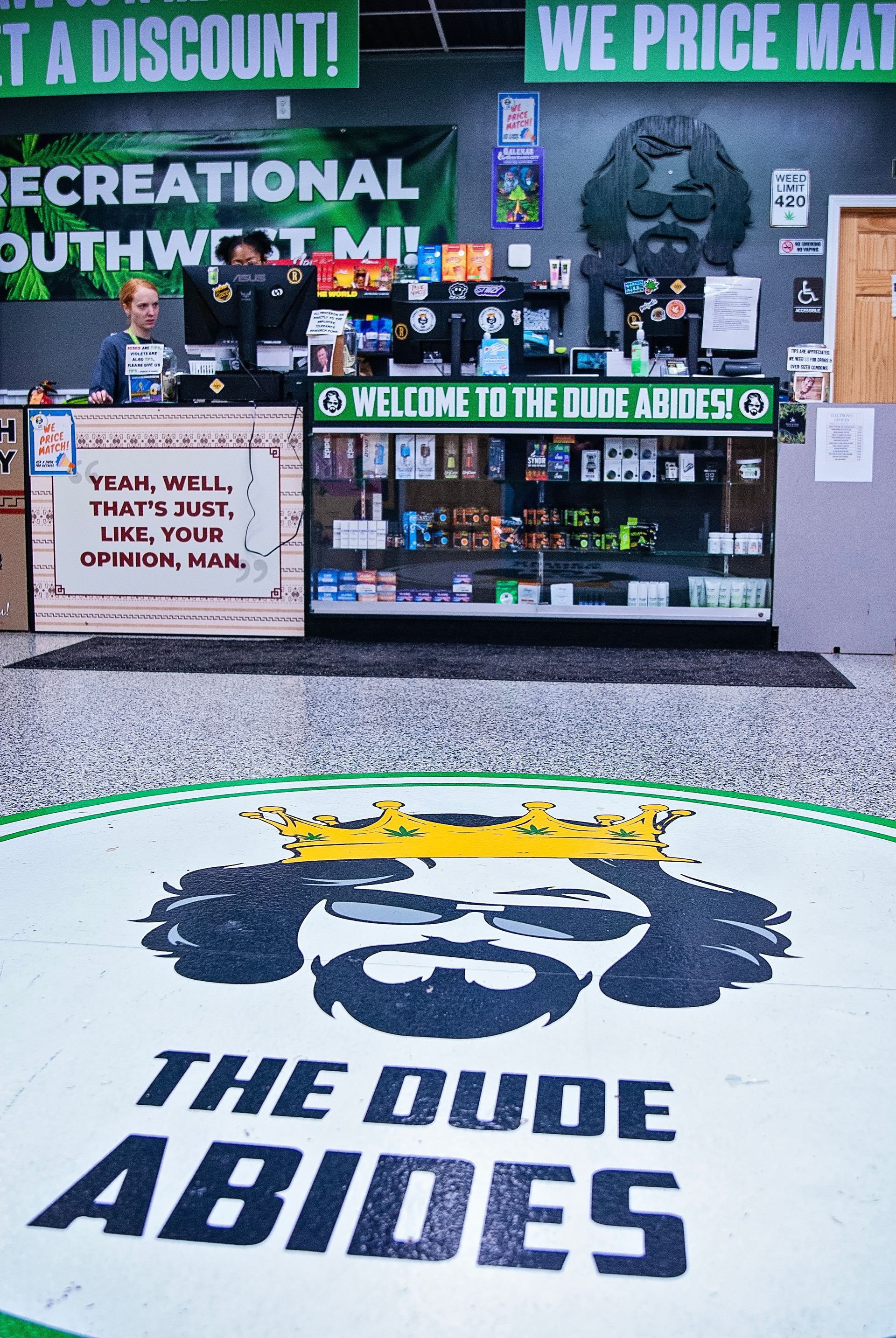 A store with a sign that says `` the dude abides '' on the floor.