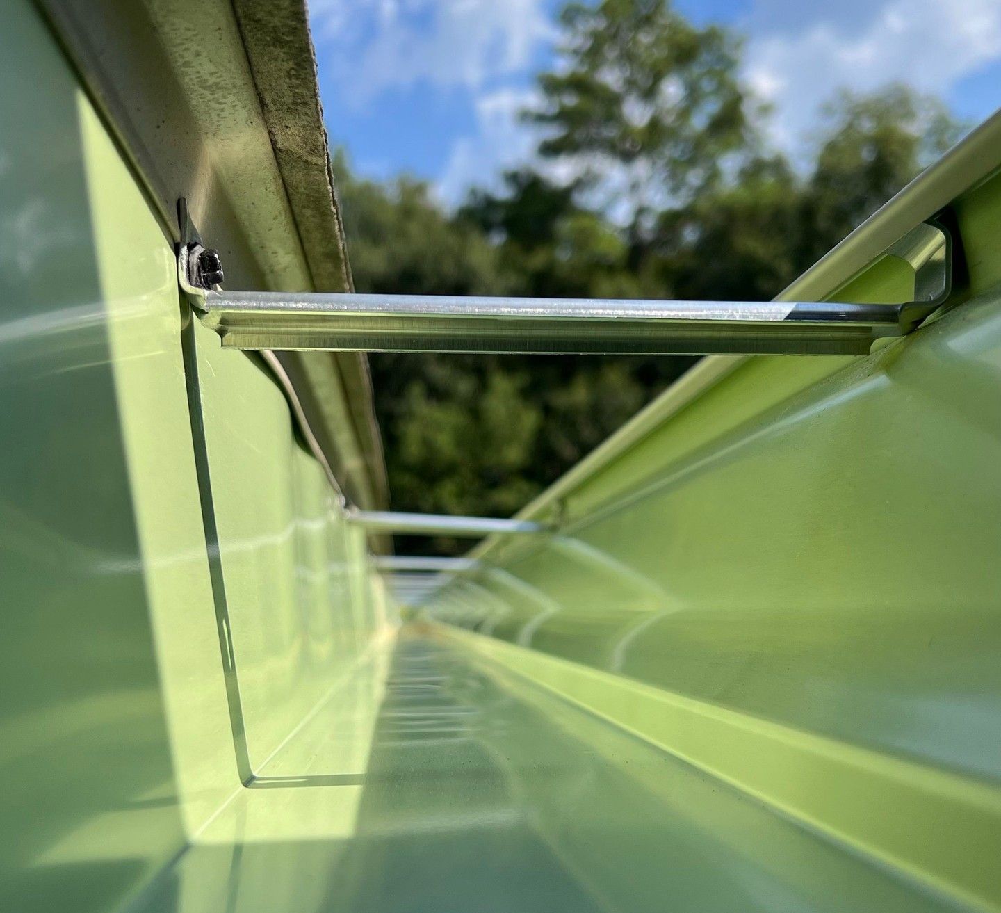 a close up of a green gutter with trees in the background .