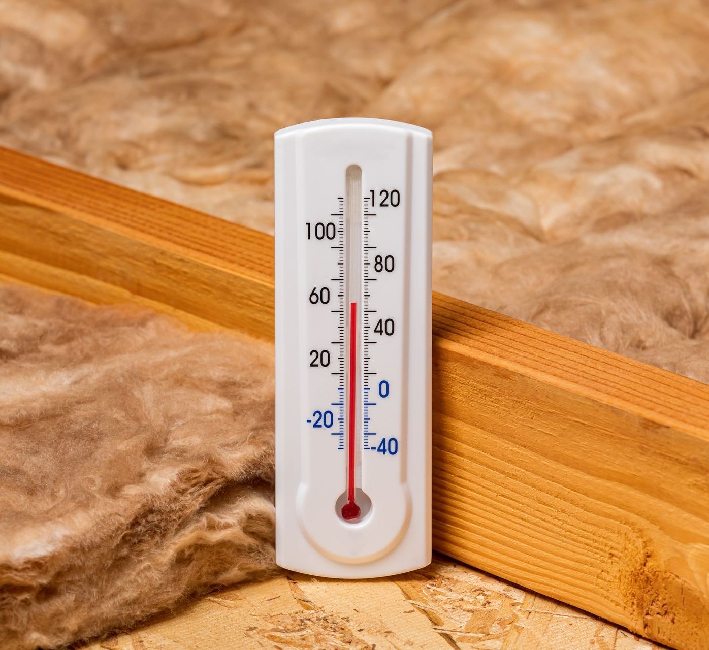 a thermometer is sitting next to a piece of wood .