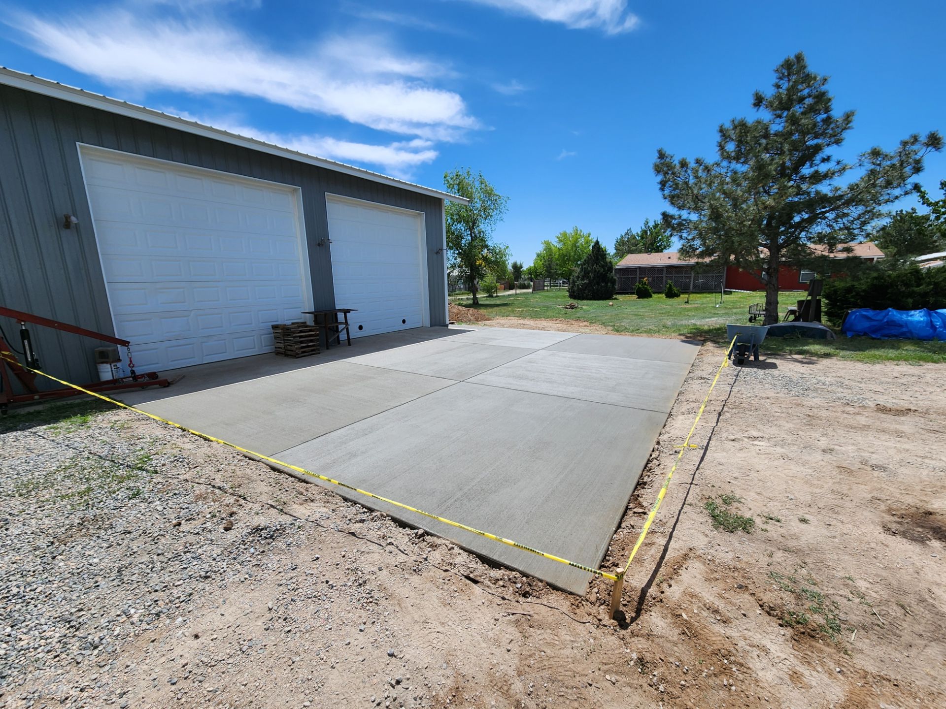 A concrete driveway is being built in front of a garage.
