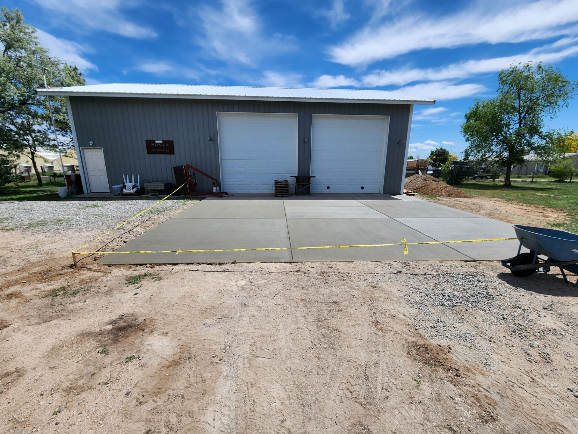 A concrete driveway is being built in front of a garage.