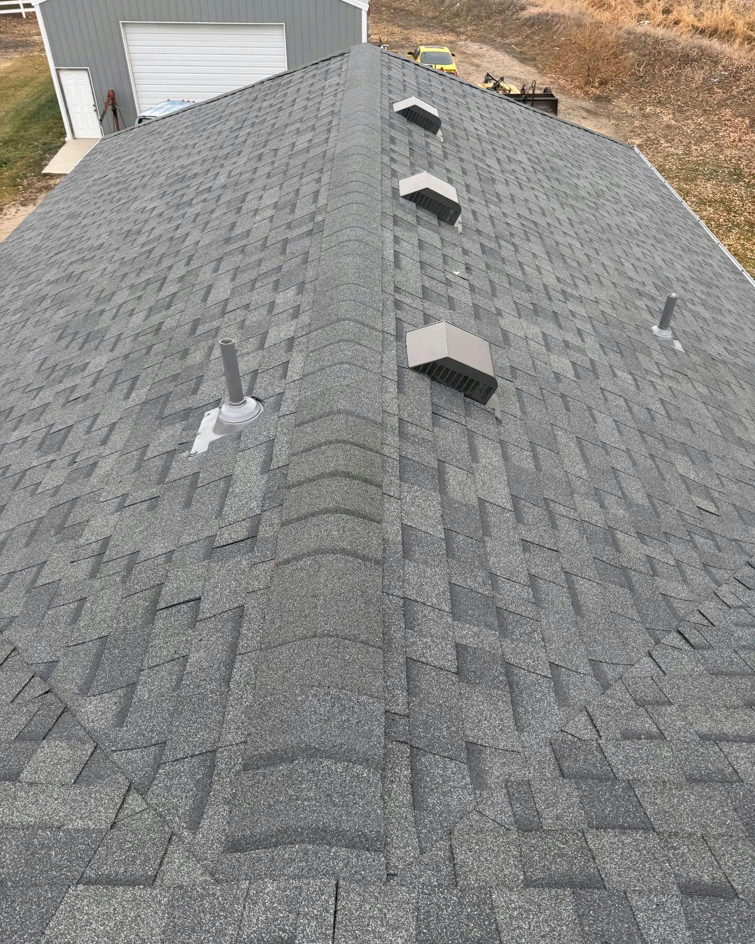 A roof with a lot of shingles and vents on it.