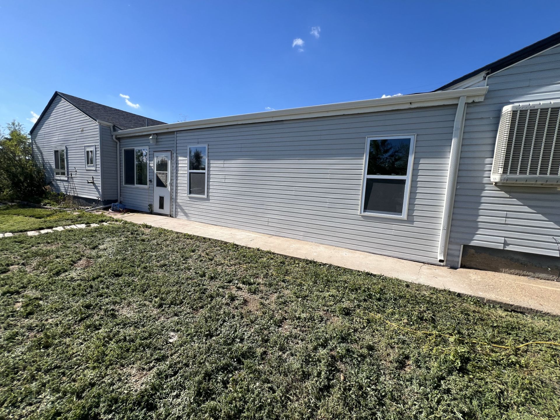 A white house with a lot of windows and a walkway leading to it.