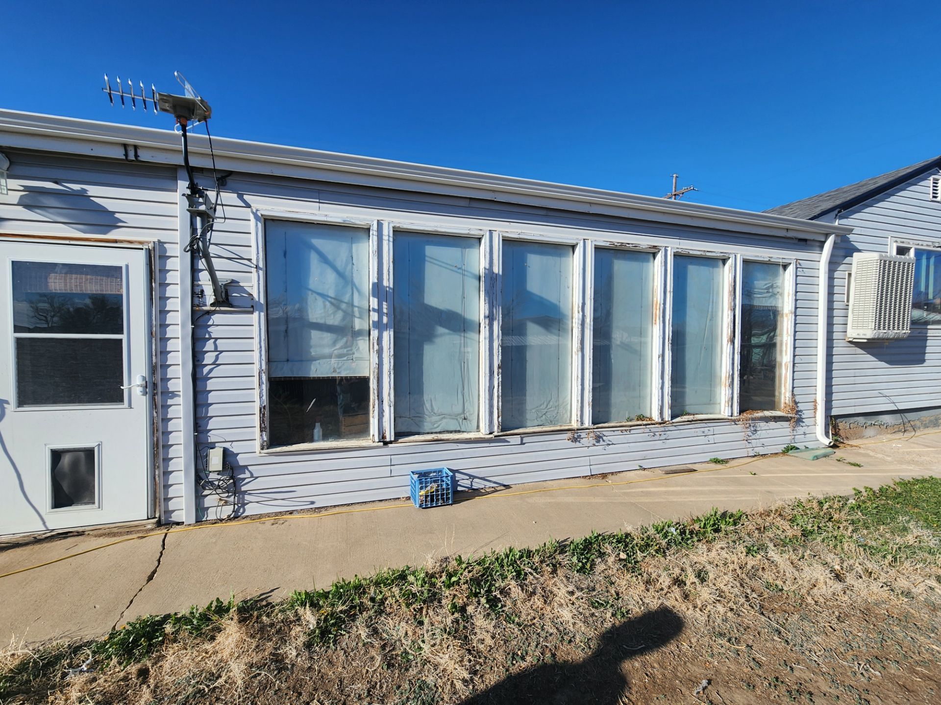A house with a lot of windows and a dog door.