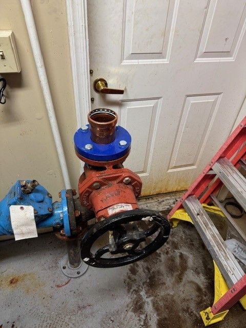 a red, 3inch commercial line with black spin wheel, blue pipes, and blue and copper connection repaired by steen & son plumbing and heating in mays landing, new jersey