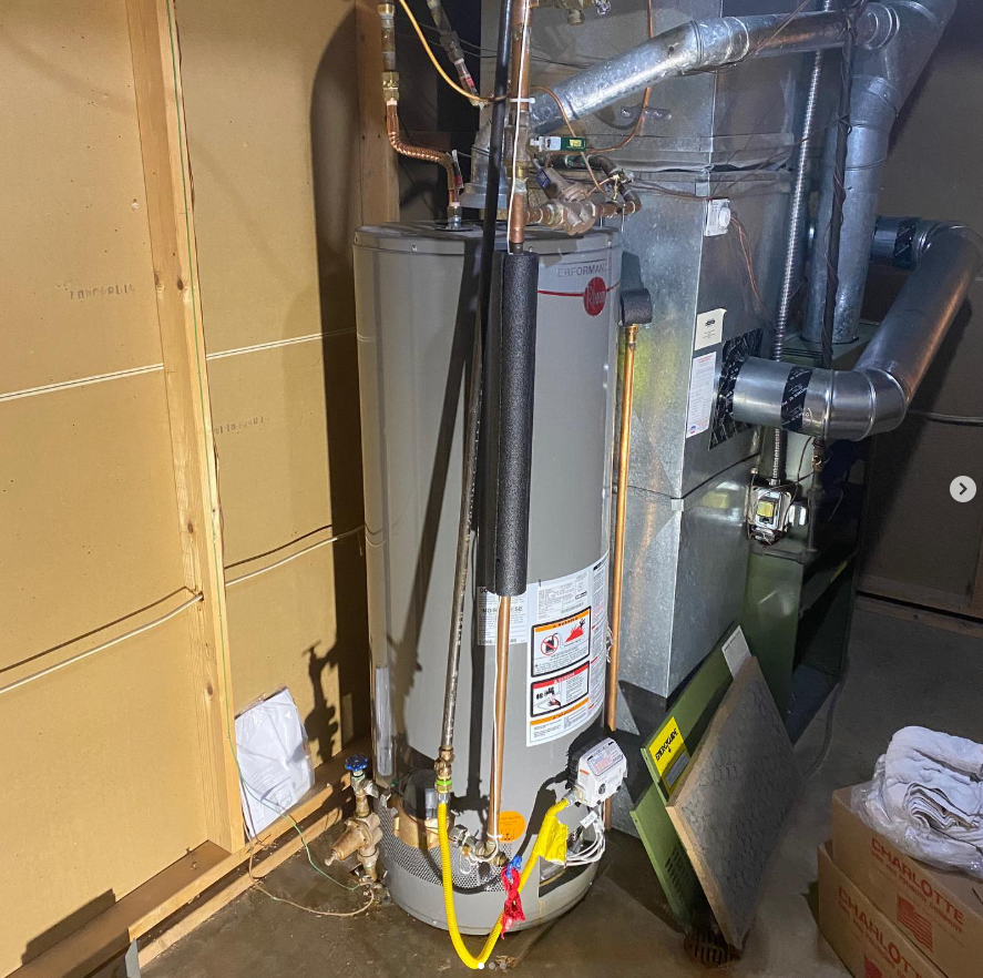 A gas water heater and furnace against a wall in a utility room installed by Steen & Son Plumbing and Heating Mays Landing, New Jersey