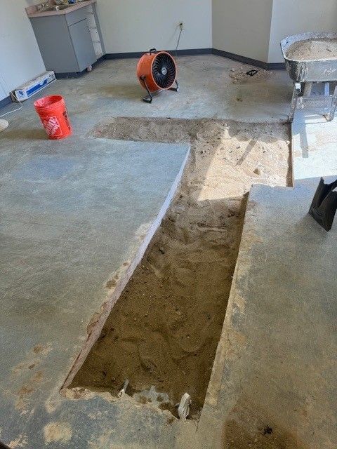 Concrete floor with excavated trench being filled in by a steen & son plumbing and heating technician in atlantic county, new jersey
