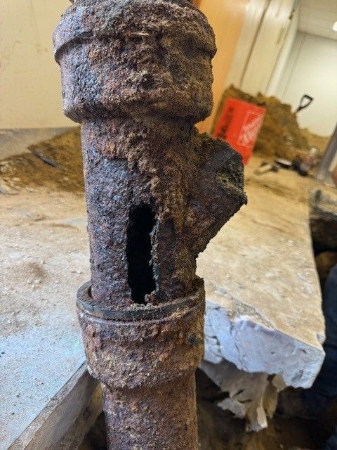 Severely corroded iron pipe with a large hole being removed by steen & son plumbing and heating in atlantic county, new jersey