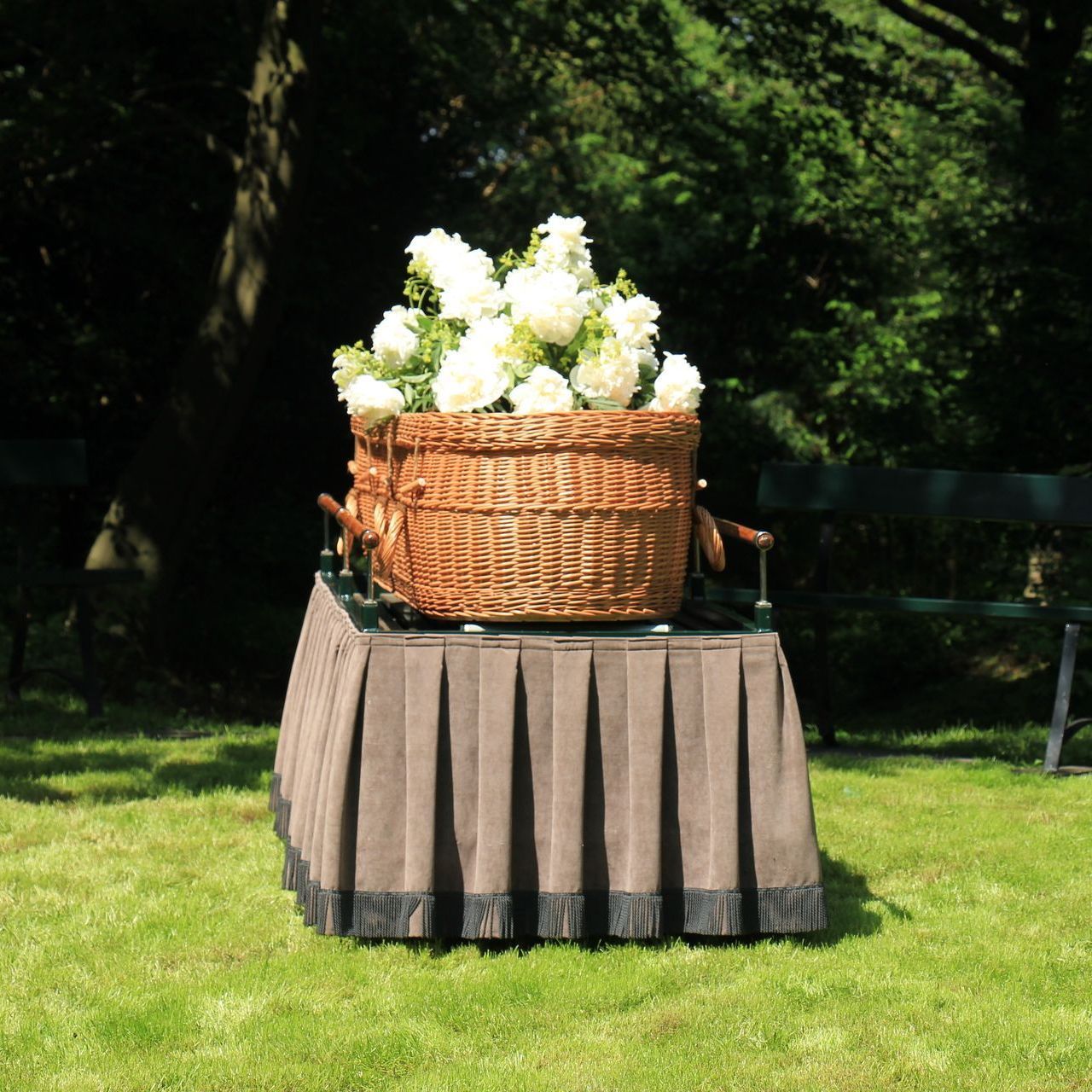 a man in a suit is opening a coffin with flowers in the background .