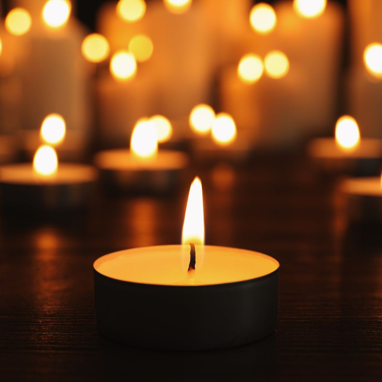 a man in a suit is opening a coffin with flowers in the background .