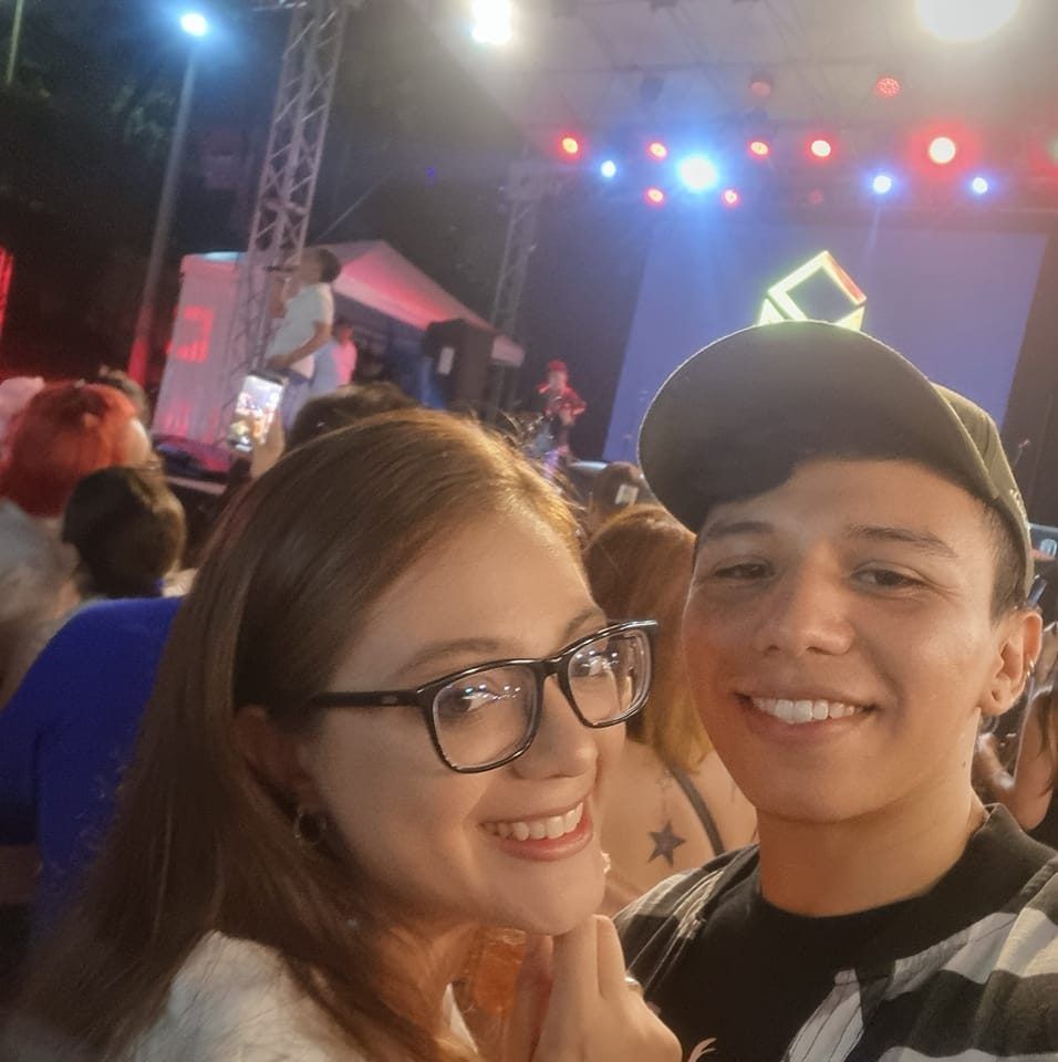Un hombre y una mujer posan para una foto en un concierto