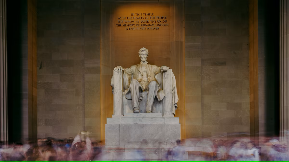 Uma estátua de Abraham Lincoln sentado em uma cadeira na frente de uma multidão.
