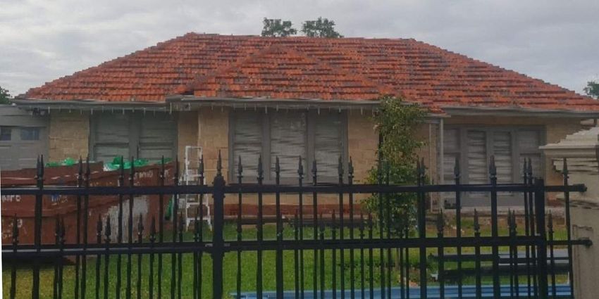 SARG Tile Roof - Image of a home with an old, tired tiled roof right before a metal reroof by SARG