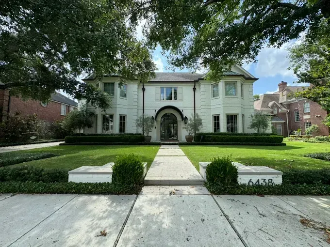 White house with manicured lawn and walkway; address 
